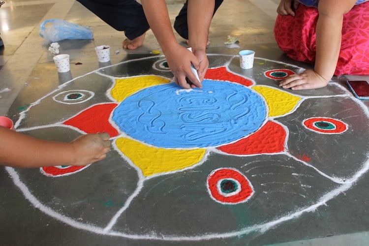 Photo of people making rangoli design for Diwali