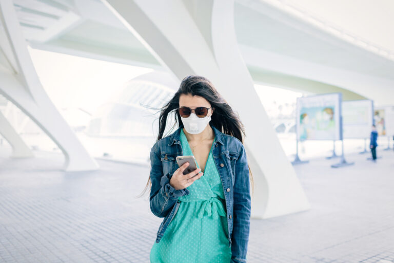 mobile wallet or mobile money is easy to send on a phone like this woman with an iphone and a blue shirt