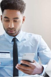 Send money by credit card: entrepreneur using a phone and looking at a credit card