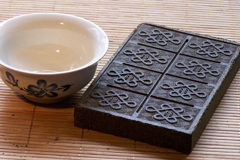 a cup of tea is sitting on a wooden block