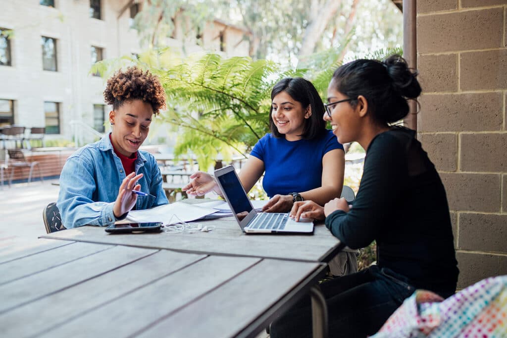 A group of students laughing and talking while studying