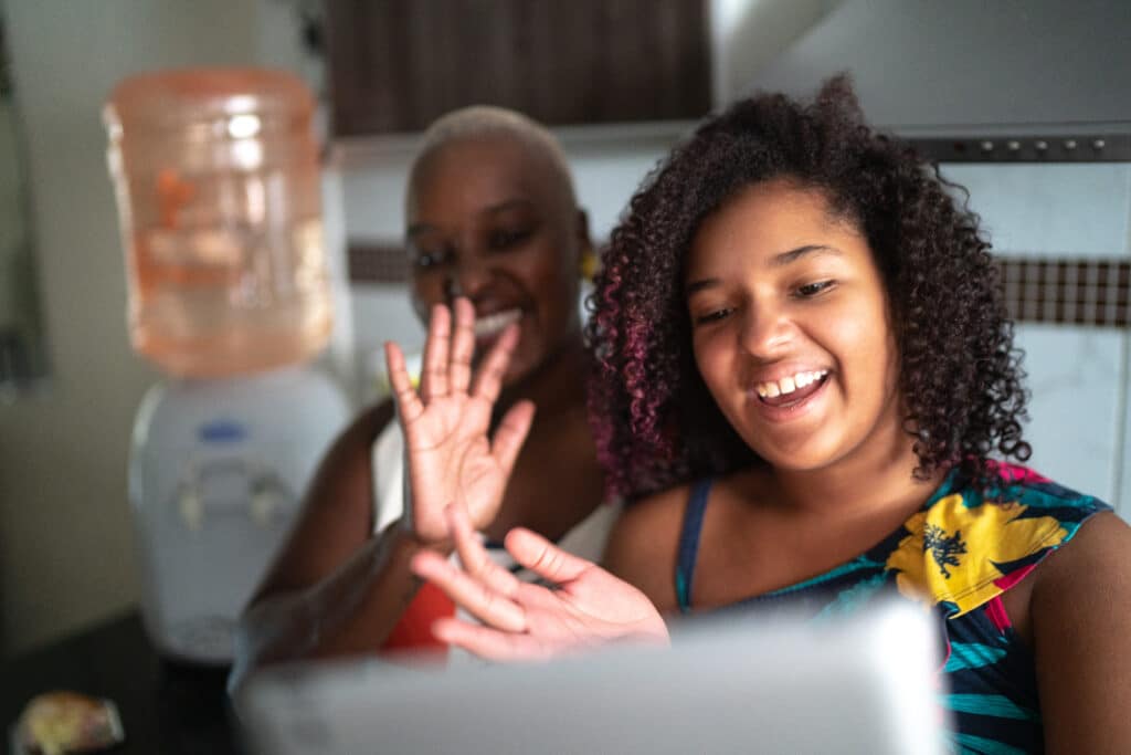 Two women waving at the iPad
