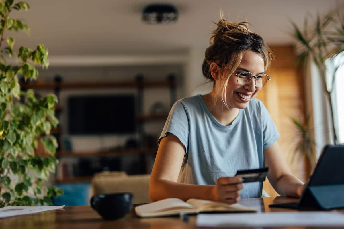 Woman holding a credit card and using a tablet