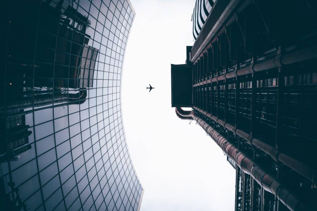 Aereo in volo visto da terra tra due palazzi