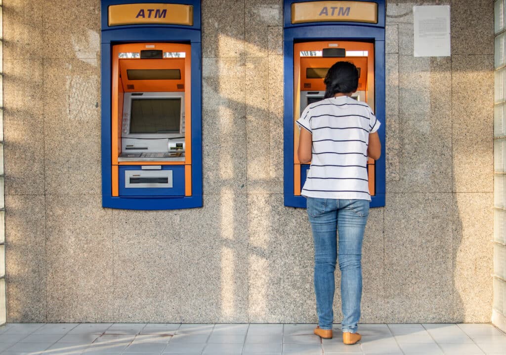 Thailand currency: woman withdrawing cash from an ATM
