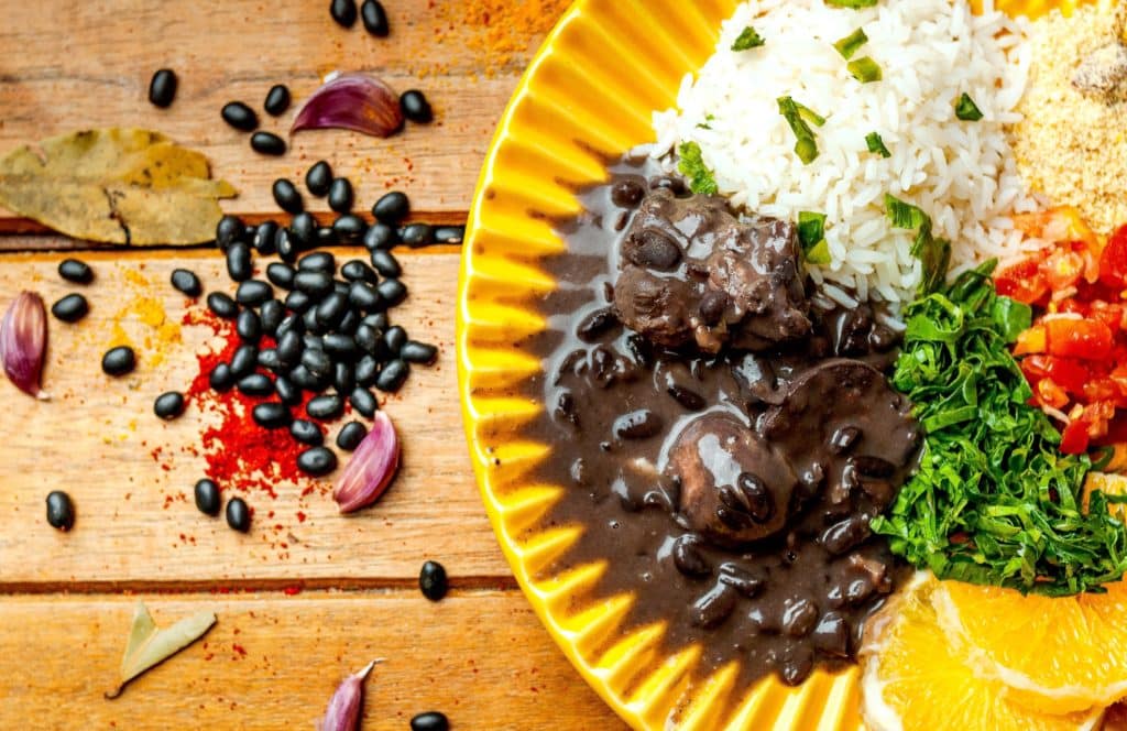 a plate of black beans, rice and beans on a wooden table