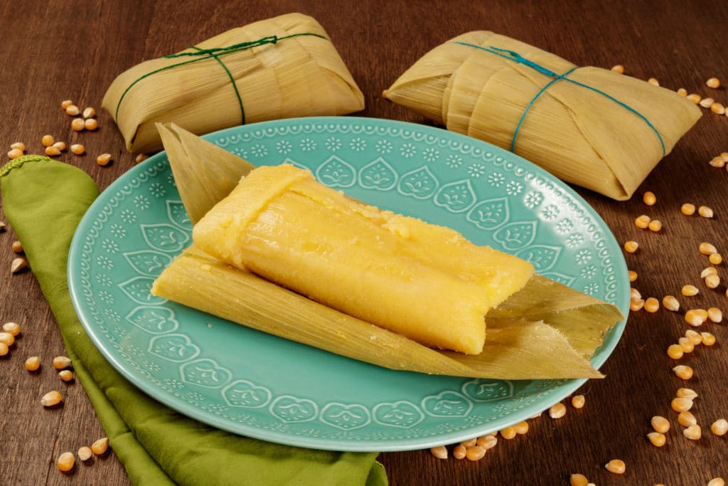 tamales on a plate with corn on it