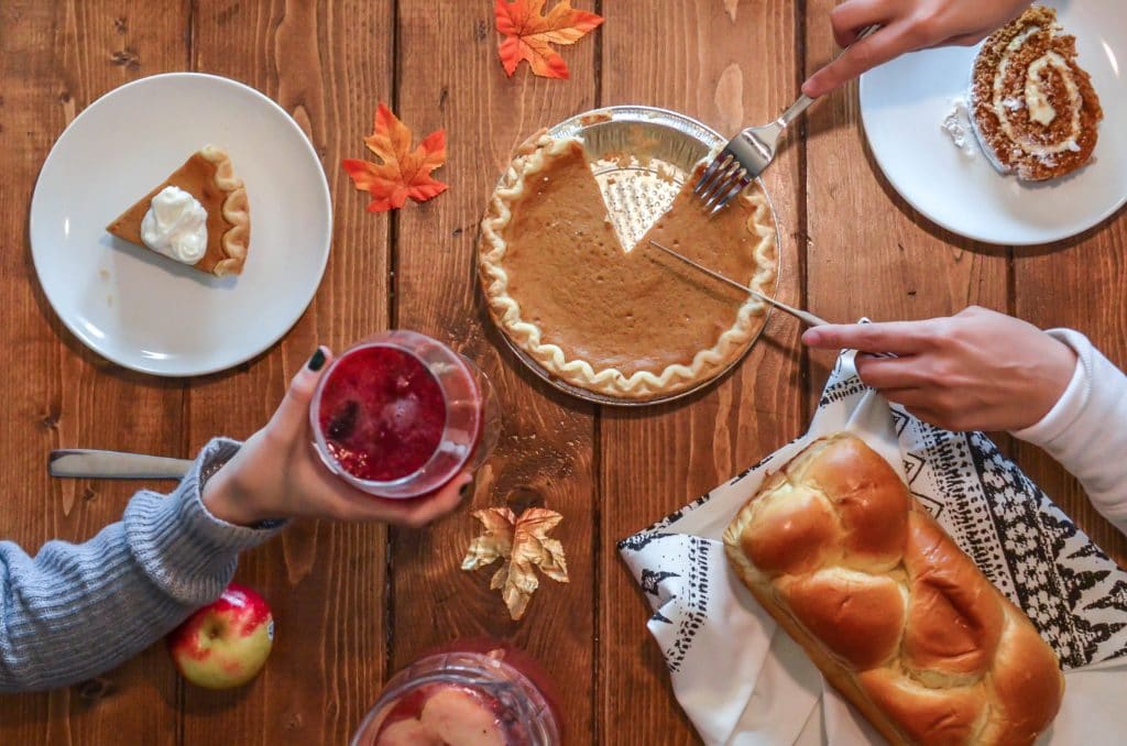 Vue d'en haut d'une table sur laquelle sont posés des desserts et des feuilles d'automne