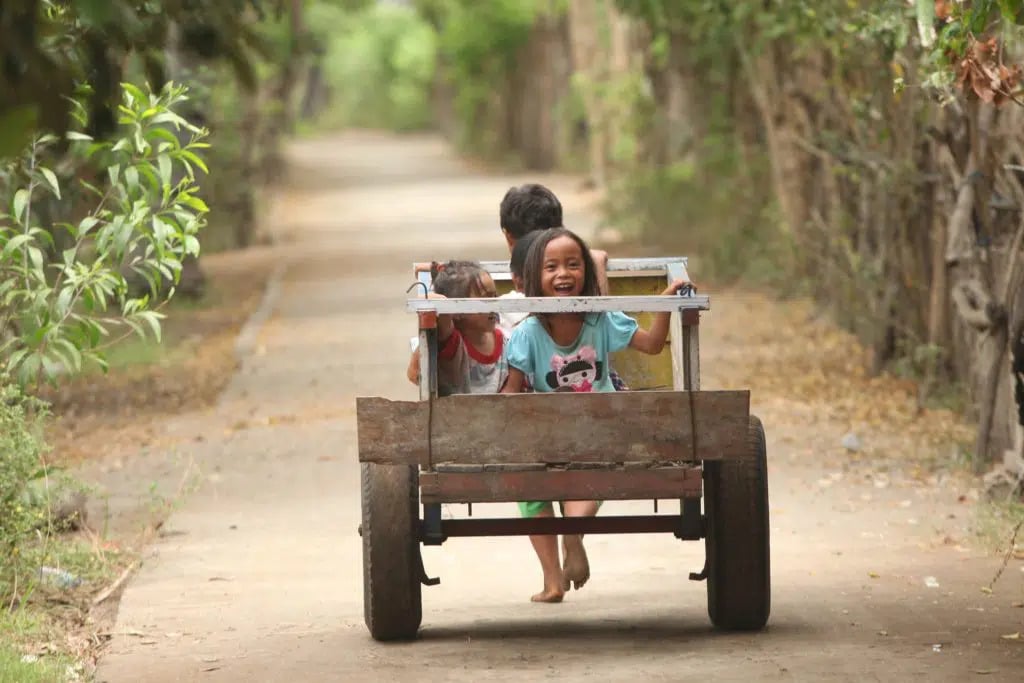 Children playing with a wooden wagon