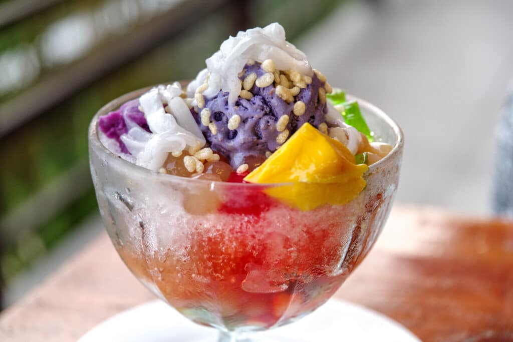 a glass of ice cream with fruit and nuts