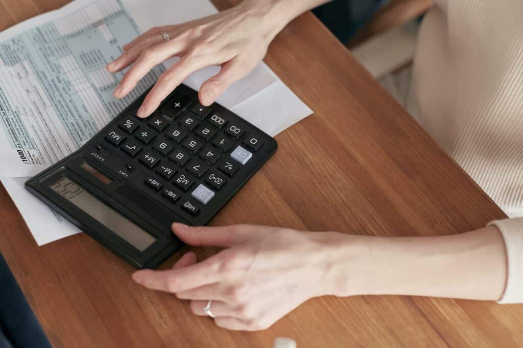 Une dame faisant des comptes avec une calculatrice