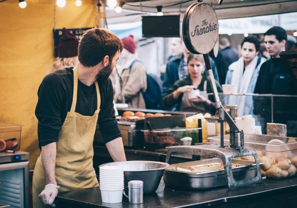 Un homme tenant un stand de nourriture dans un marché