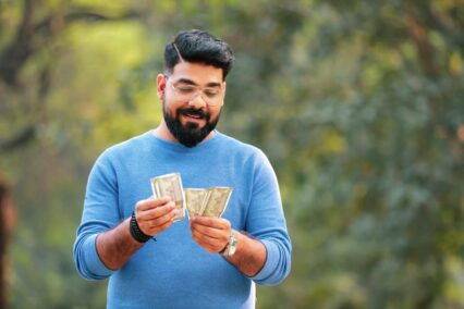 Indian currency: man counting some Indian rupee bills