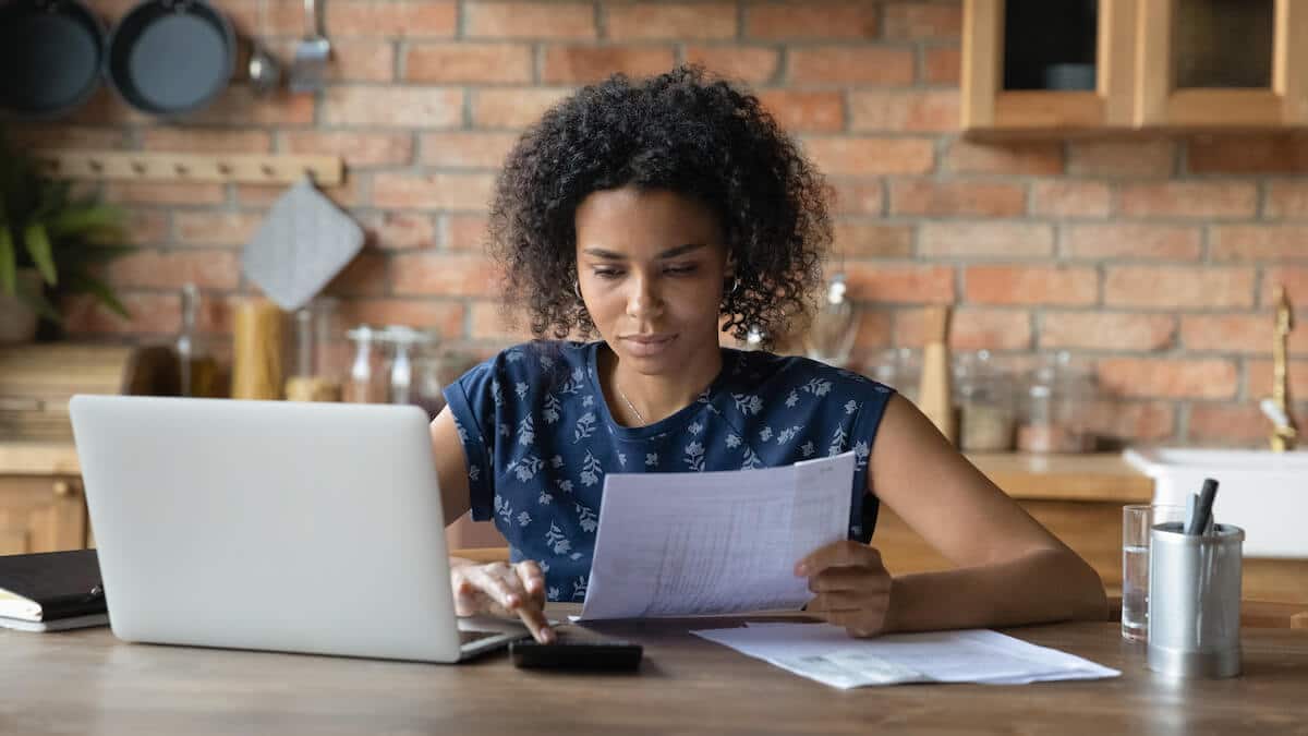 Woman using a calculator and holding a document