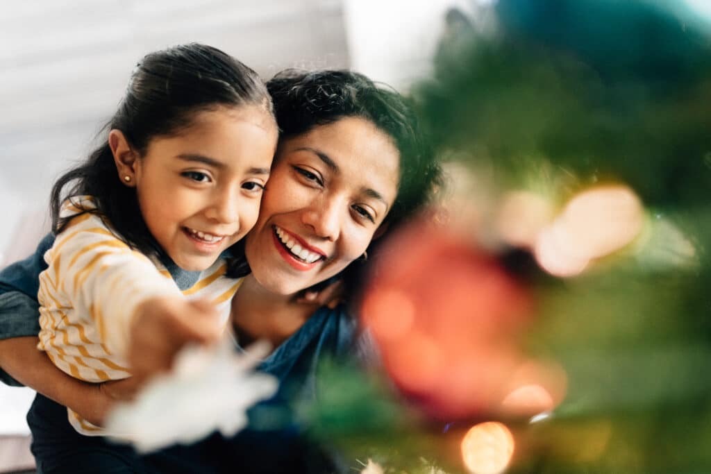 Spanish Christmas Songs - Family Smiling at Tree