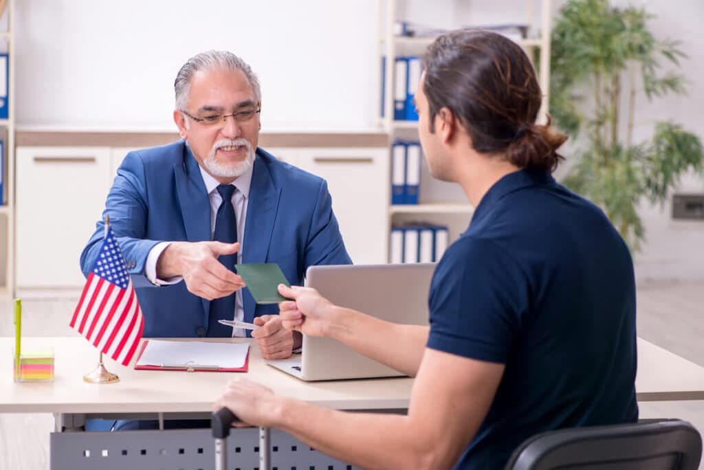Alien registration number: man handing his passport to a government personnel