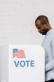 Can you vote if you have a green card: man standing and voting