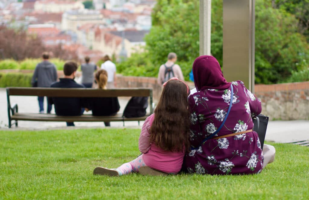 Une maman et sa fille assises sur une pelouse