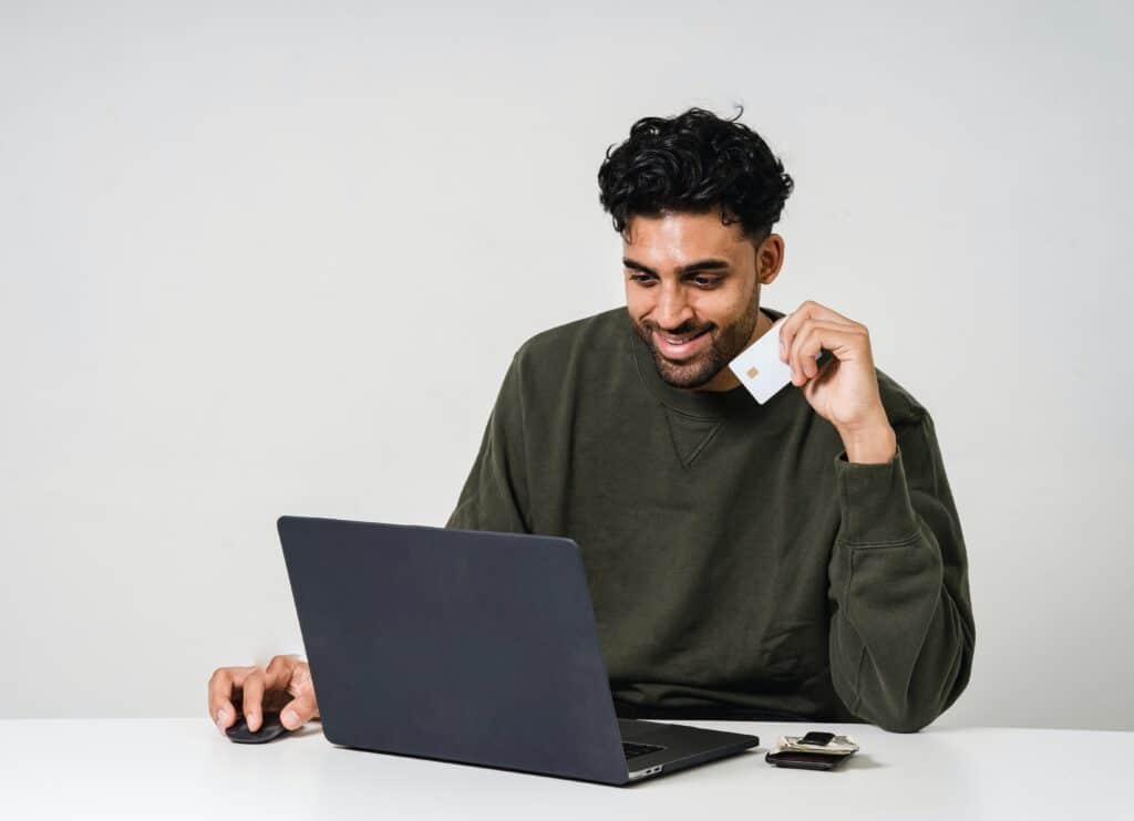 Man doing online banking transaction holding his bank card