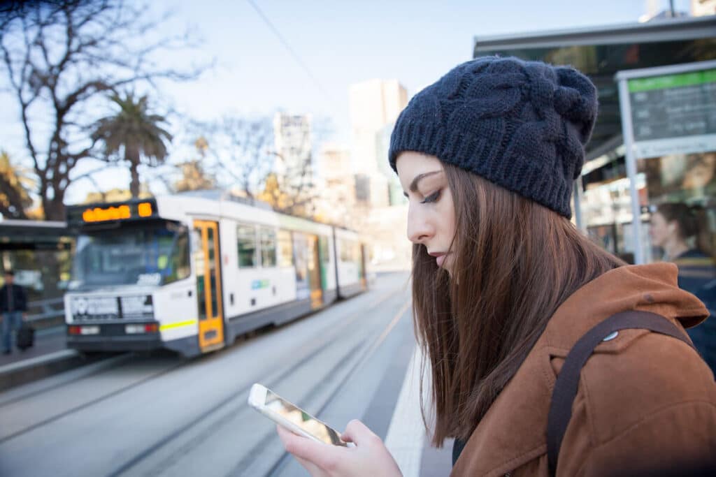 Woman using her phone while waiting for the train