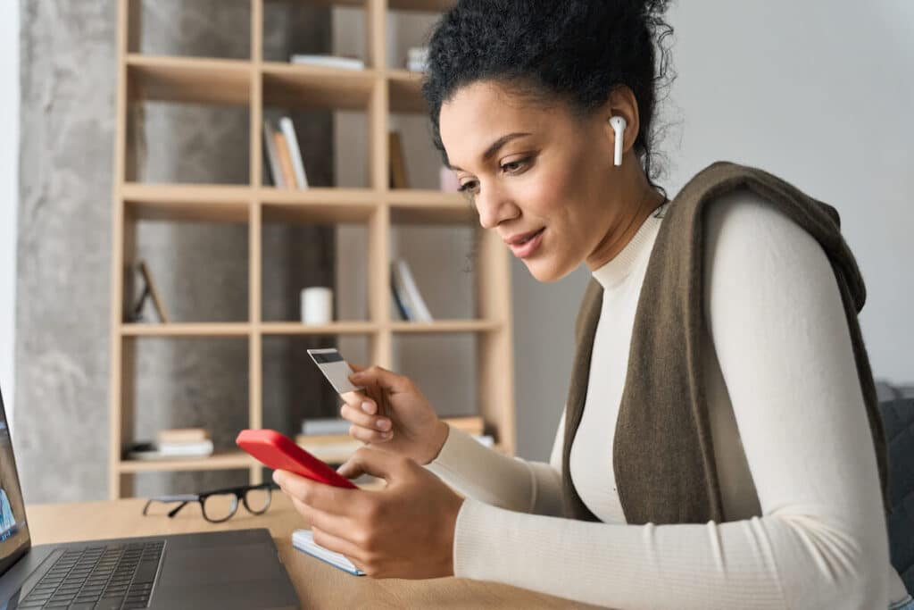 woman using credit card while sitting at desk
