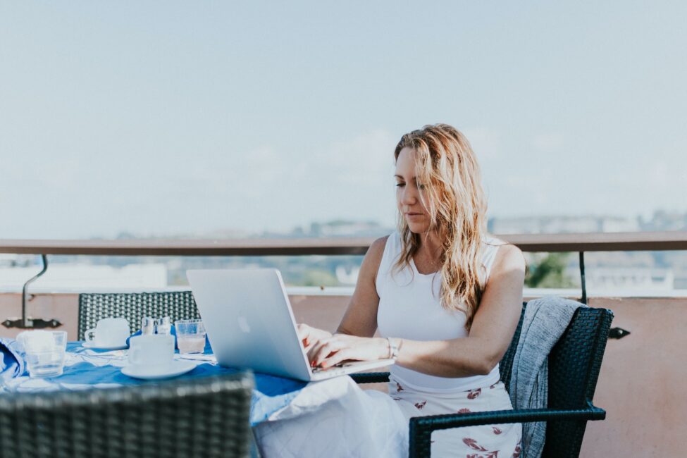 Person working on a laptop at an outdoor café.