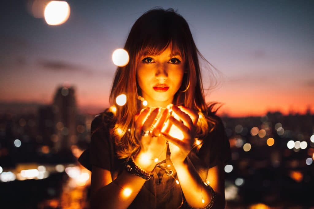 Winter solstice: a woman holding a string of lights
