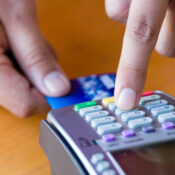 Close up customer hand holding and paying for order by credit card in cafe and restaurant.