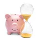 Piggy bank with hourglass on white.