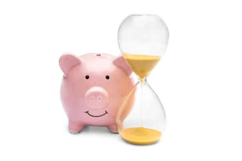 Piggy bank with hourglass on white.