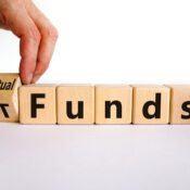 Mutual funds vs ETF symbol - Businessman turns a cube and changes words 'ETF' to 'mutual funds'.