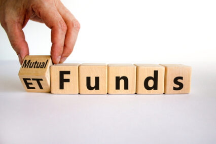 Mutual funds vs ETF symbol - Businessman turns a cube and changes words 'ETF' to 'mutual funds'.
