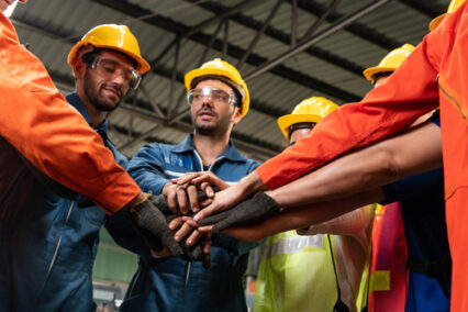 Skillful worker stand together showing teamwork in the factory.