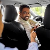 Taxi car driver taking credit card from passenger