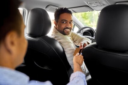 Taxi car driver taking credit card from passenger