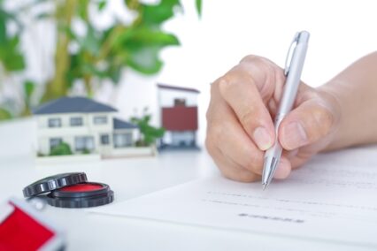 Hands of the person signing the housing contract