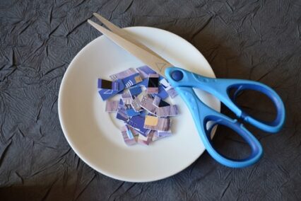 Credit card cut into small pieces with a pair of scissors