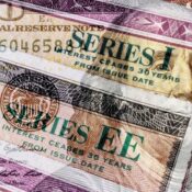 Series I and Series EE US Savings Bonds with 100 dollar bill overlay. Savings bonds are debt securities issued by the US.