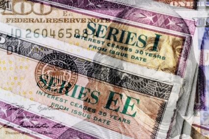 Series I and Series EE US Savings Bonds with 100 dollar bill overlay. Savings bonds are debt securities issued by the US.