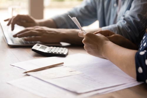 Close up young couple calculating domestic bills.