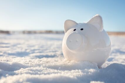 Piggy bank in the snow background, freezing assets, saving for Christmas or Winter holidays