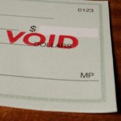 Blank green generic check on table with void stamp