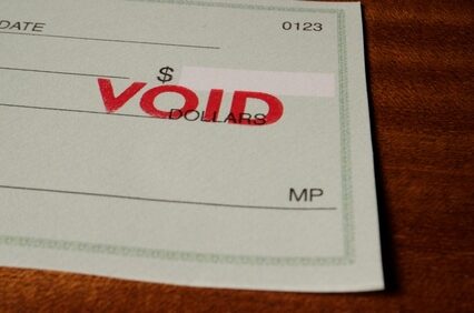 Blank green generic check on table with void stamp