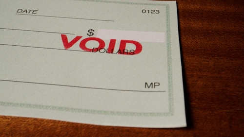 Blank green generic check on table with void stamp