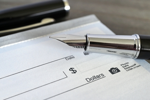 Fountain pen on a blank bank check cheque