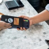 Customer holding smartphone with virtual credit card screen showing