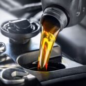 Fresh car oil being poured into a car engine.