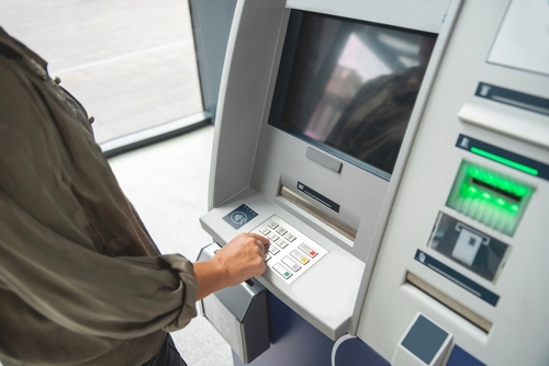 hand entering PIN number on ATM, postal code for electronic bank transfer