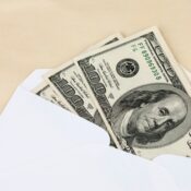 Money placed in white envelope for financial budgeting.
