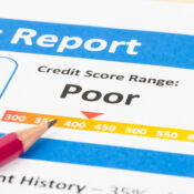 Poor credit score report with pen and calculator